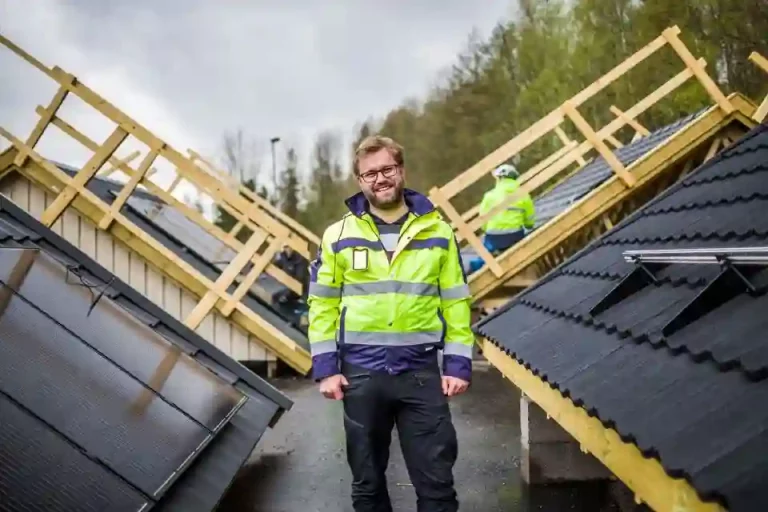 Smilende arbeidsmann med solceller på tak